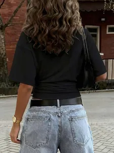 Vista posteriore di maglietta nera con vita arricciata e jeans azzurri