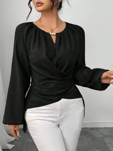 Detailansicht eines schwarzen Damen-Langarmshirts mit Wickeltaille und asymmetrischem Saum.