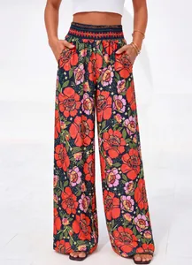 Gros plan sur le motif floral rouge éclatant et la texture du tissu de ce pantalon d'été