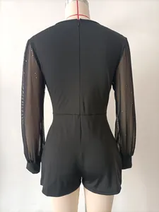 Detailansicht der Rückseite eines schwarzen, langärmeligen Mesh-Jumpsuits auf Mannequin