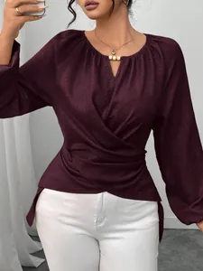Elegante dunkelrote langärmelige Wickelbluse mit unregelmäßigem Saum und Taillendetails.