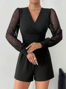 Detailansicht eines schwarzen V-Ausschnitt-Playsuits mit glitzernden Netzärmeln
