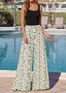 Elegant woman in black sleeveless square neck jumpsuit with polka dot wide leg pants
