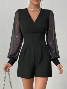 Detail eines eleganten schwarzen V-Ausschnitt-Jumpsuits mit glitzernden Netzärmeln