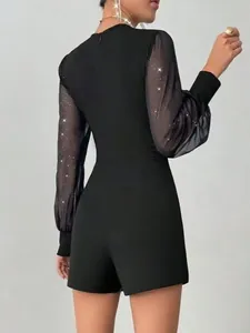 Detailansicht der Rückseite eines schwarzen Jumpers mit glitzernden Netzärmeln.