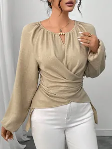 Detail des gewebten khakifarbenen Langarmshirts mit Wickeldesign und asymmetrischem Saum