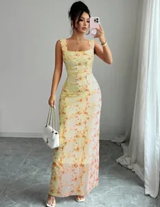 Model wearing a slim-fit yellow floral print maxi dress featuring a square neckline.