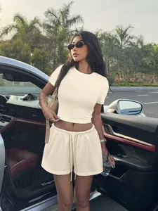Ensemble beige tendance deux pièces avec crop top côtelé et short à cordon sur mannequin.