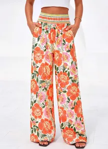 Vue détaillée du pantalon large à taille haute pour femme avec imprimé floral orange et rose.