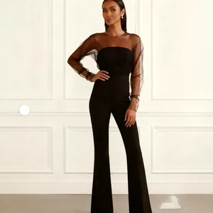 Combinaison noire élégante avec détails en résille, manches transparentes et pattes.
