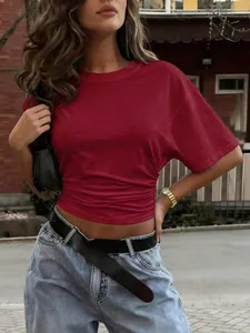 Dettaglio della t-shirt rossa a maniche corte con vita arricciata effetto snellente.