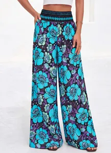 Détail d'un pantalon large à taille haute avec un imprimé floral bleu et violet.