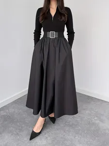 Front view of an elegant black long-sleeved dress featuring a cinched belted waist