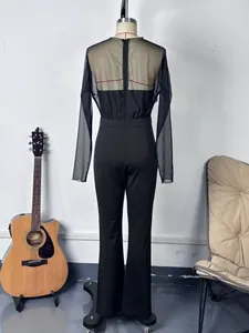 Vue arrière d'une combinaison noire chic pour femme avec empiècement en mesh et coupe ajustée.