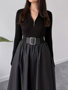 Close-up of black Hepburn dress featuring V-neck zipper and waist-cinching belt detail