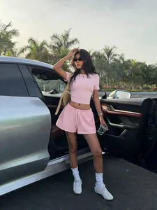 Détail lifestyle d'un ensemble crop top rose et short à cordon pour femme avec mannequin