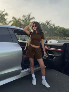 Femme asiatique portant un ensemble top court marron et short à cordon au véhicule