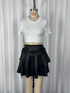 Detailed view of a stylish double-layer ruffled mini skirt with a white crop top on a mannequin.