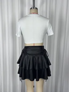 Rear view of white short crop top paired with black double-layered ruffled mini skirt
