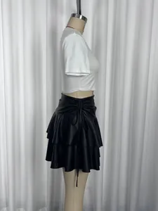 Side view showing details of black ruffled double-layered mini skirt with adjustable side tie