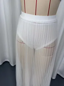 Vue détaillée d'une jupe longue plissée en mesh blanc transparent portée par un mannequin