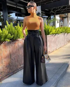 Fashion model wearing high-waisted black PU leather wide-leg pants with a wide belt