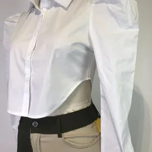Detailed view of white cropped lapel shirt with puffed sleeves and asymmetrical hemline