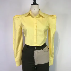 Detail shot of a yellow puffed shoulder cropped shirt displayed on a professional mannequin