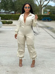 Trendy beige long sleeve cargo jumpsuit for women with deep V-neck and utility pockets detail