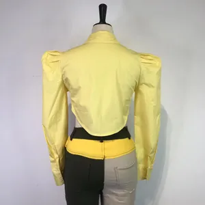 Back view of a yellow cropped puff-sleeve shirt with a curved hem design