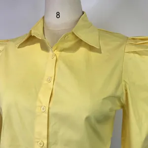 Close-up detail of a stylish yellow long-sleeve shirt featuring a classic lapel collar.