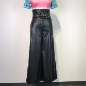 Detailed view of high-waisted black PU leather wide-leg trousers with eyelet belt.