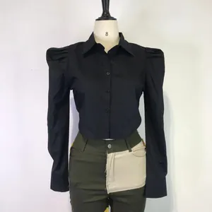 Detailed view of a black cropped long sleeve shirt with elegant puff shoulders and lapel collar.