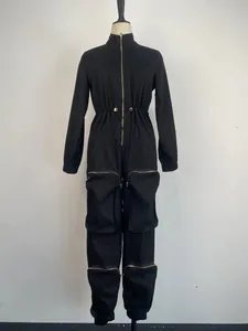 Detailed view of black utility jumpsuit with cinched waist and multi-pocket metal zippers