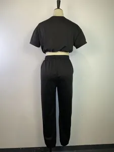 Vista posteriore di un completo nero due pezzi da donna con felpa corta e pantaloni