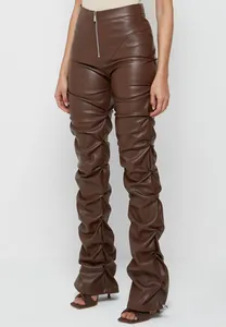 Pantalones de mujer en ecocuero marrón con detalle fruncido en las piernas y cremallera.