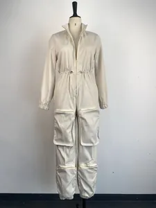 Front detail of a stylish cream utilitarian jumpsuit with cargo pockets and metal zipper.