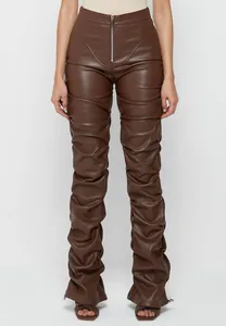Detalle de pantalones de cuero PU marrón con fruncidos, cintura alta y cremallera
