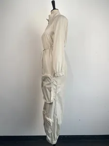 Side profile of a cream cargo jumpsuit featuring an elasticated waist and zippered pockets