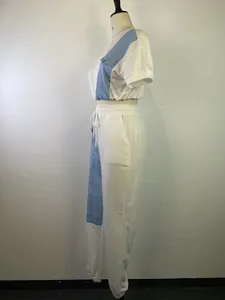 Vista laterale di crop top bianco a maniche corte e pantaloni in denim patchwork
