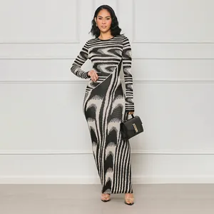 Elegant long-sleeved bodycon maxi dress featuring irregular black and white abstract print.