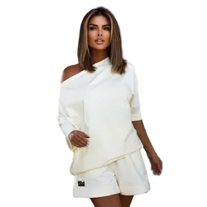 Close-up view of a stylish off-the-shoulder sweatshirt and shorts set for women in beige.