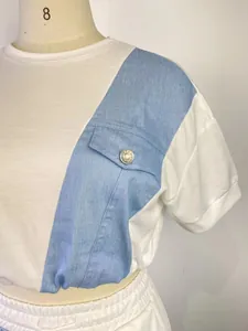 Dettaglio ravvicinato della felpa bianca a maniche corte con inserto in denim