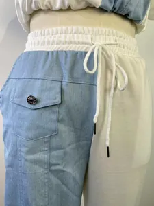 Dettaglio ravvicinato dei pantaloni in denim patchwork a vita alta con coulisse e tasca