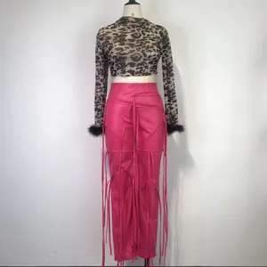 Detailopname van de roze PU-leren broek met een ingewikkeld vetersysteem