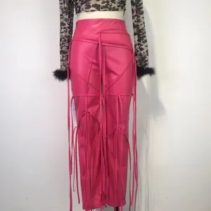 Detail van roze PU-leren broek met decoratieve vetersluiting en franje-elementen