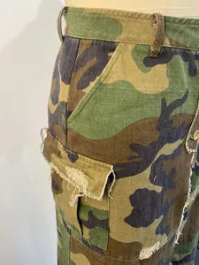 Detailed view of women's camouflage cargo skirt with corduroy fabric and raw hem