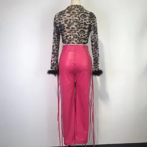 Achteraanzicht van roze PU-leren broek met zijvetersluiting en lange franjes details