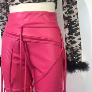 Detailopname van een roze PU-leren strakke broek met modieuze vetersluiting in de taille
