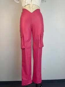 Close-up detail of bright hot pink PU leather cargo pants with a V-cut low waist